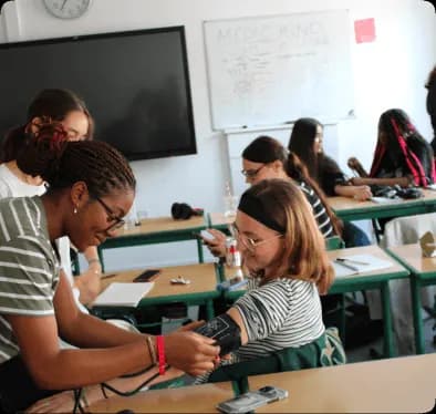 Students taking blood pressure in medical class
