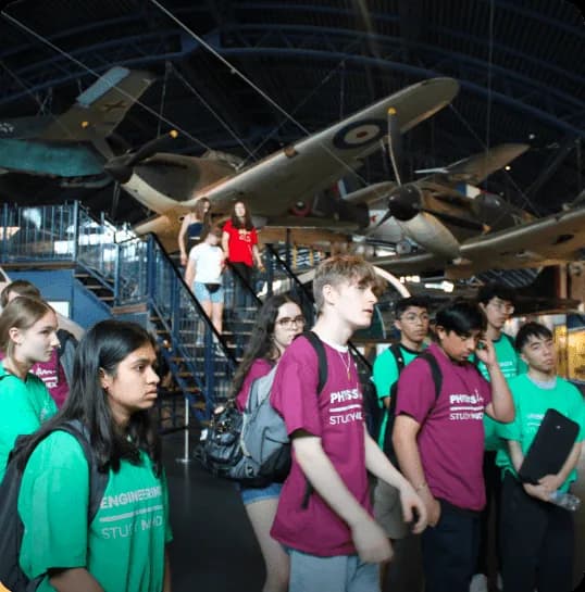 Students in museum with vintage airplanes